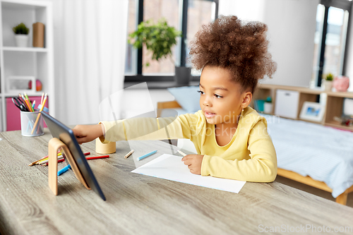 Image of little african girl with tablet pc drawing at home