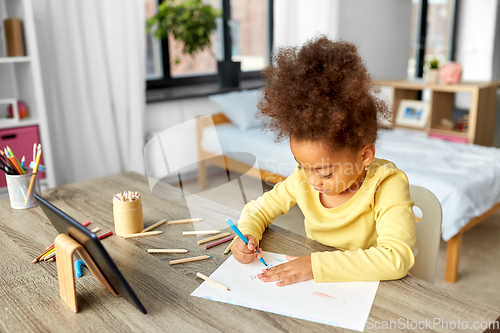 Image of little girl drawing with coloring pencils at home