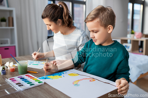 Image of mother and son with colors drawing at home