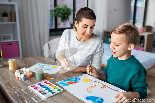 Image of mother and son with colors drawing at home