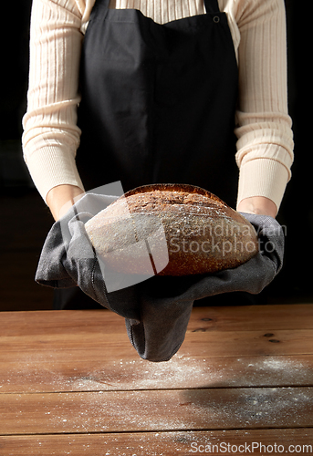 Image of female baker with homemade bread at bakery