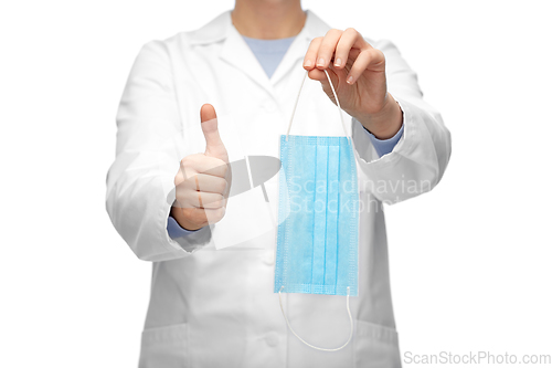 Image of female doctor with medical mask showing thumbs up