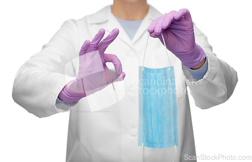 Image of female doctor with medical mask showing ok gesture