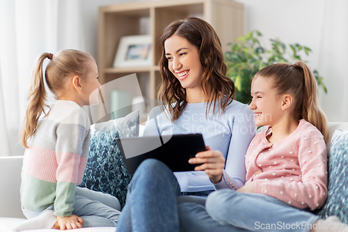 Image of happy mother and daughters with tablet pc at home