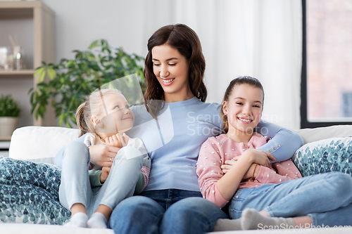 Image of happy smiling mother with two daughters at home