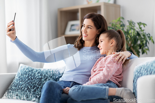 Image of happy family taking selfie by smartphone at home
