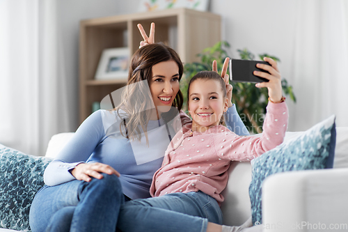 Image of happy family taking selfie by smartphone at home