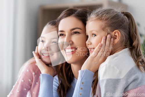 Image of happy smiling mother with two daughters at home