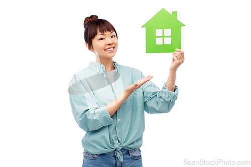 Image of smiling asian woman holding green house