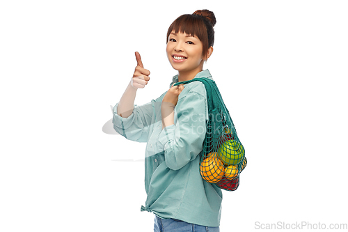 Image of happy asian woman with food in reusable string bag