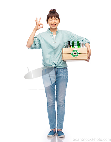 Image of smiling young asian woman sorting glass waste