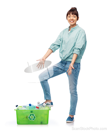 Image of smiling young asian woman sorting plastic waste