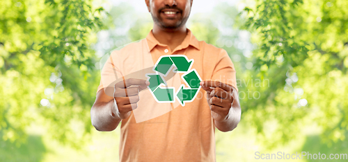 Image of smiling indian man holding green recycling sign