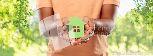 Image of close up of african man holding green house