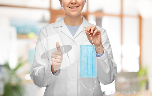 Image of female doctor with medical mask showing thumbs up