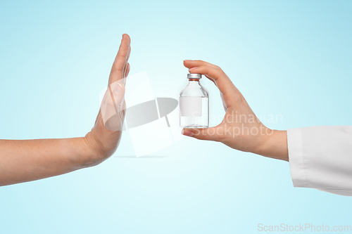 Image of hand with medicine and showing stop gesture