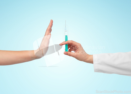 Image of hand with syringe and showing stop gesture