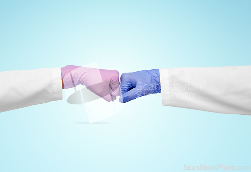 Image of hands of doctors in gloves make fist bump gesture