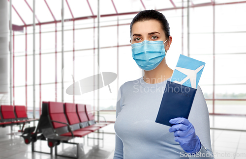 Image of young woman in mask with air ticket and passport