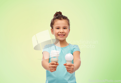 Image of smiling girl comparing different light bulbs