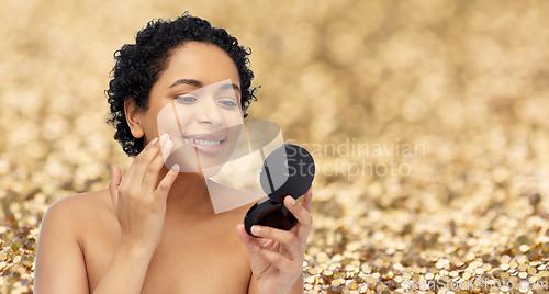 Image of smiling african american woman looking to mirror