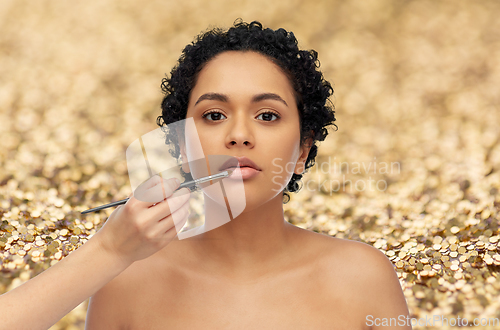 Image of woman and hand of make up artist with brush