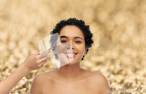 Image of happy woman and hand of make up artist with brush