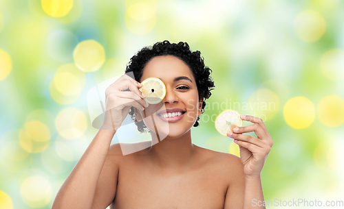 Image of african american woman making eye mask of lemons