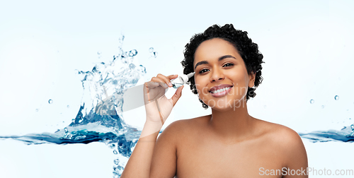 Image of happy young african american woman with eye drops