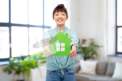 Image of smiling asian woman holding green house