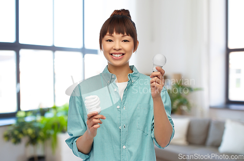 Image of asian woman holding energy saving lighting bulb