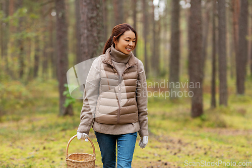 Image of young woman picking mushrooms in autumn forest