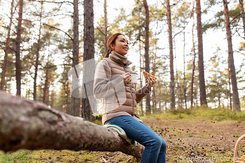 Image of woman with mushrooms drinks tea and eats in forest