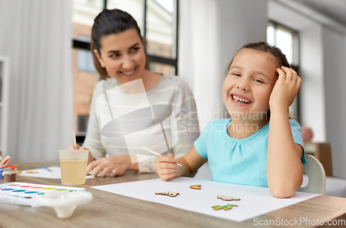 Image of happy mother with little daughter drawing at home