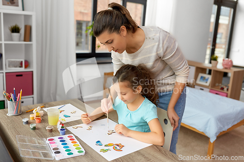 Image of mother with little daughter drawing at home