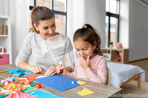 Image of daughter with mother making applique at home