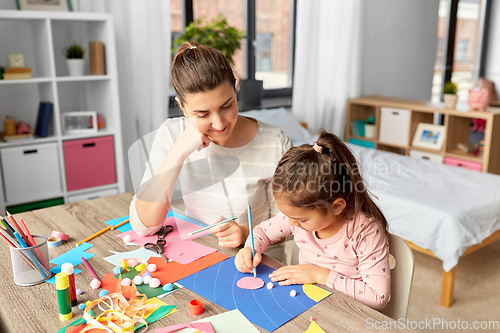 Image of daughter with mother making applique at home