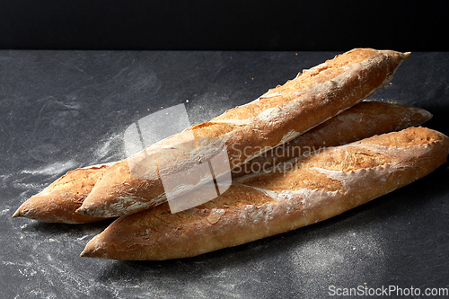 Image of baguette bread on table over dark background