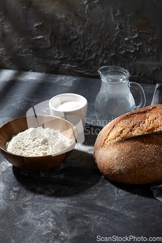 Image of bread, wheat flour, salt and water in glass jug