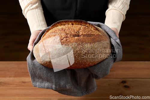 Image of female baker with homemade bread at bakery