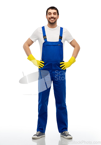 Image of happy male worker or cleaner in overal and gloves