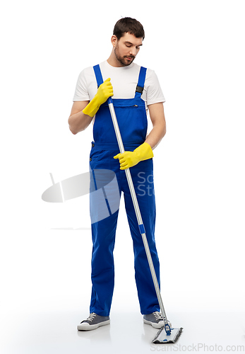 Image of male cleaner in overal cleaning floor with mop