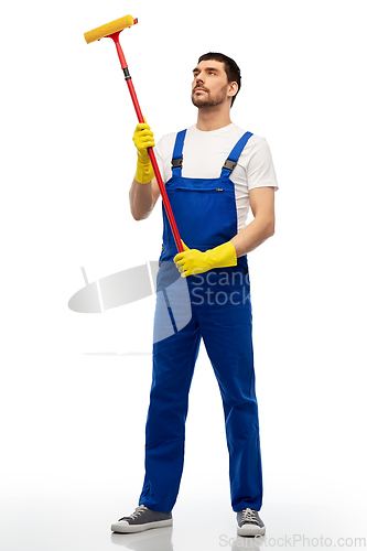 Image of male cleaner in overal with window cleaning mop