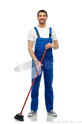 Image of male cleaner in overall cleaning floor with broom