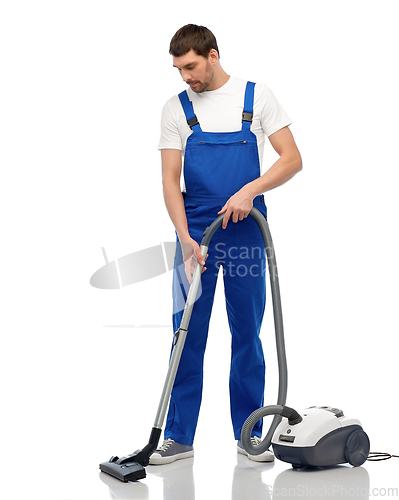 Image of male worker cleaning floor with vacuum cleaner