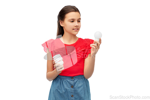 Image of smiling girl comparing different light bulbs