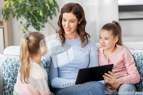 Image of happy mother and daughters with tablet pc at home