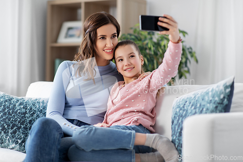 Image of happy family taking selfie by smartphone at home