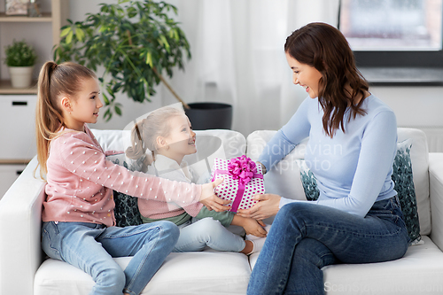 Image of daughters giving present to happy mother