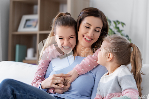 Image of happy smiling mother with two daughters at home